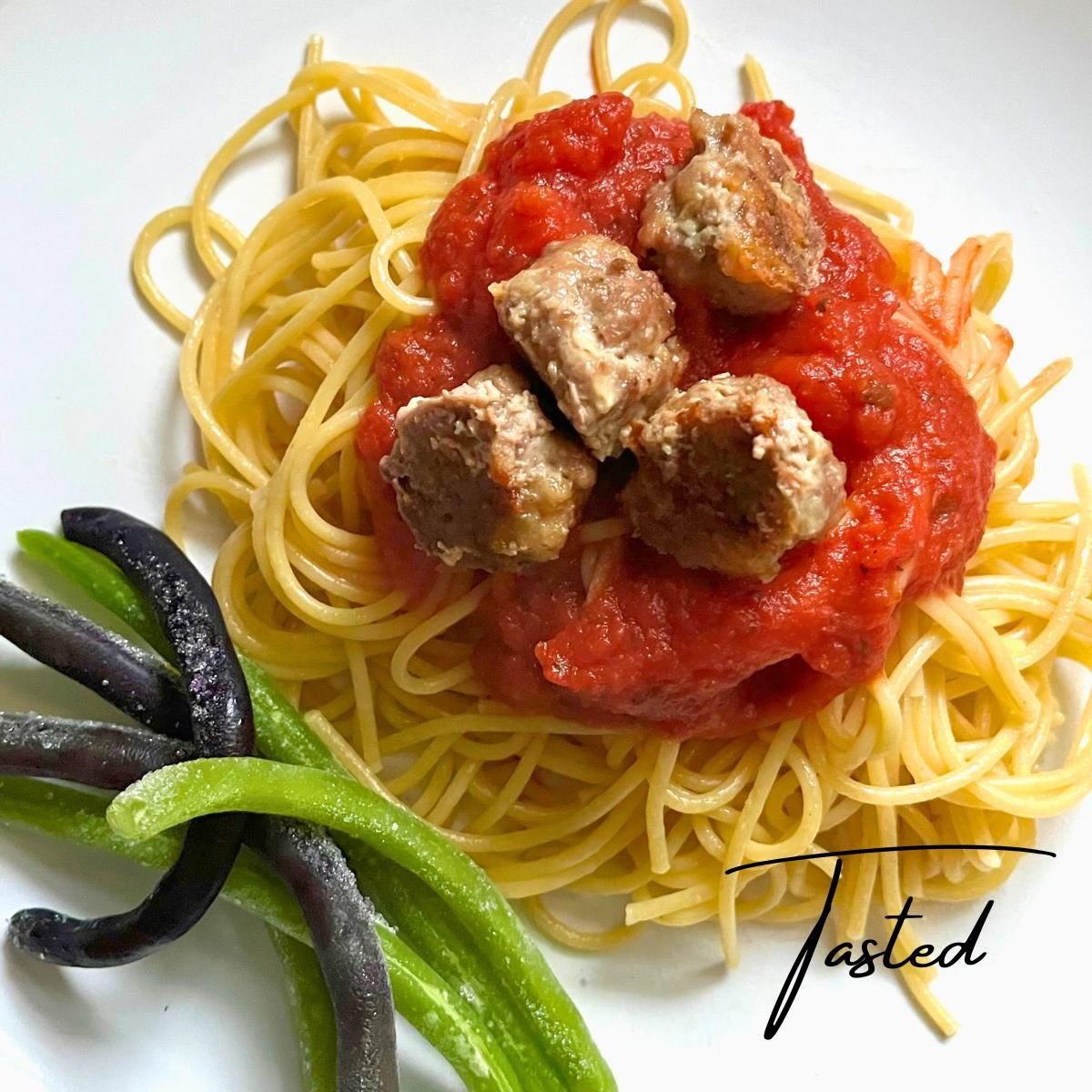 Italian-style meatballs in marinara sauce over spaghetti, with green beans on the side