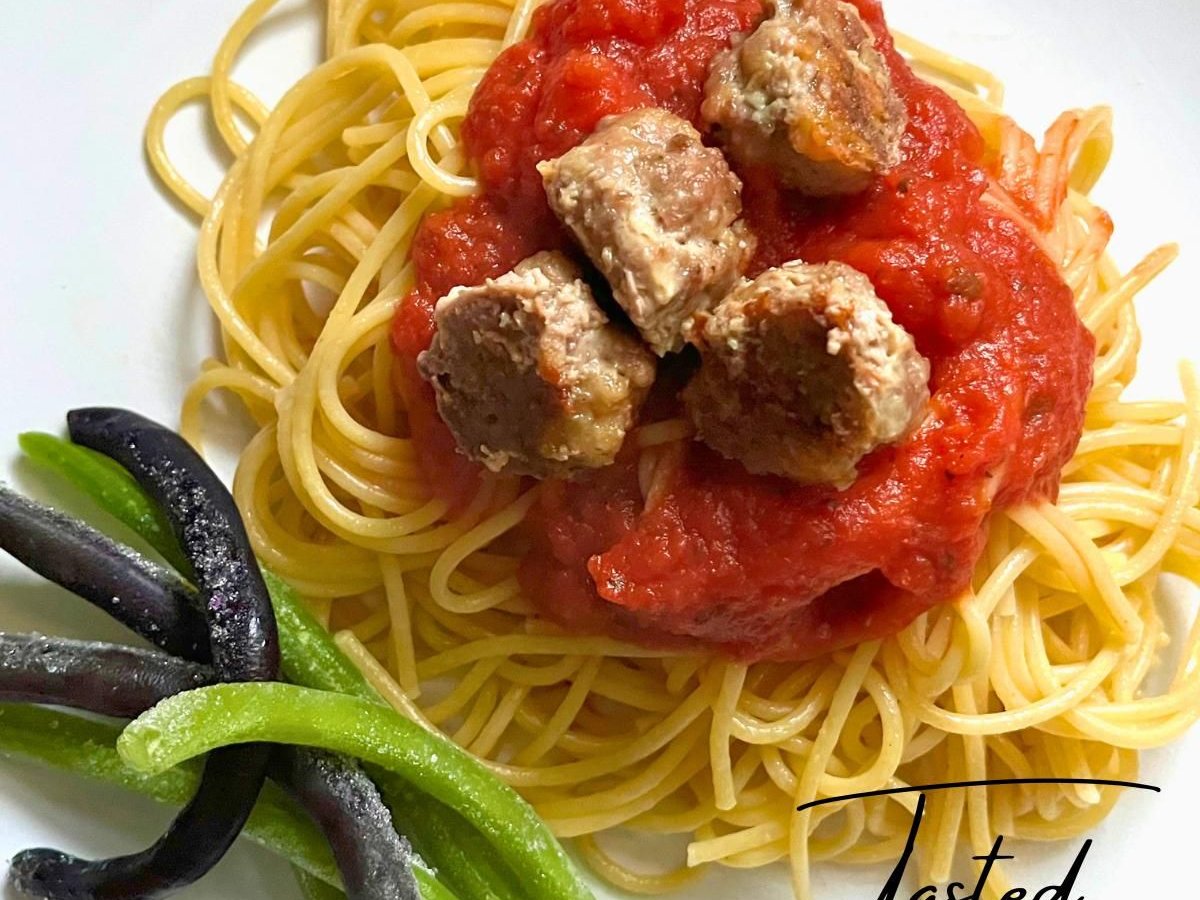 Italian-style meatballs in marinara sauce over spaghetti, with green beans on the side