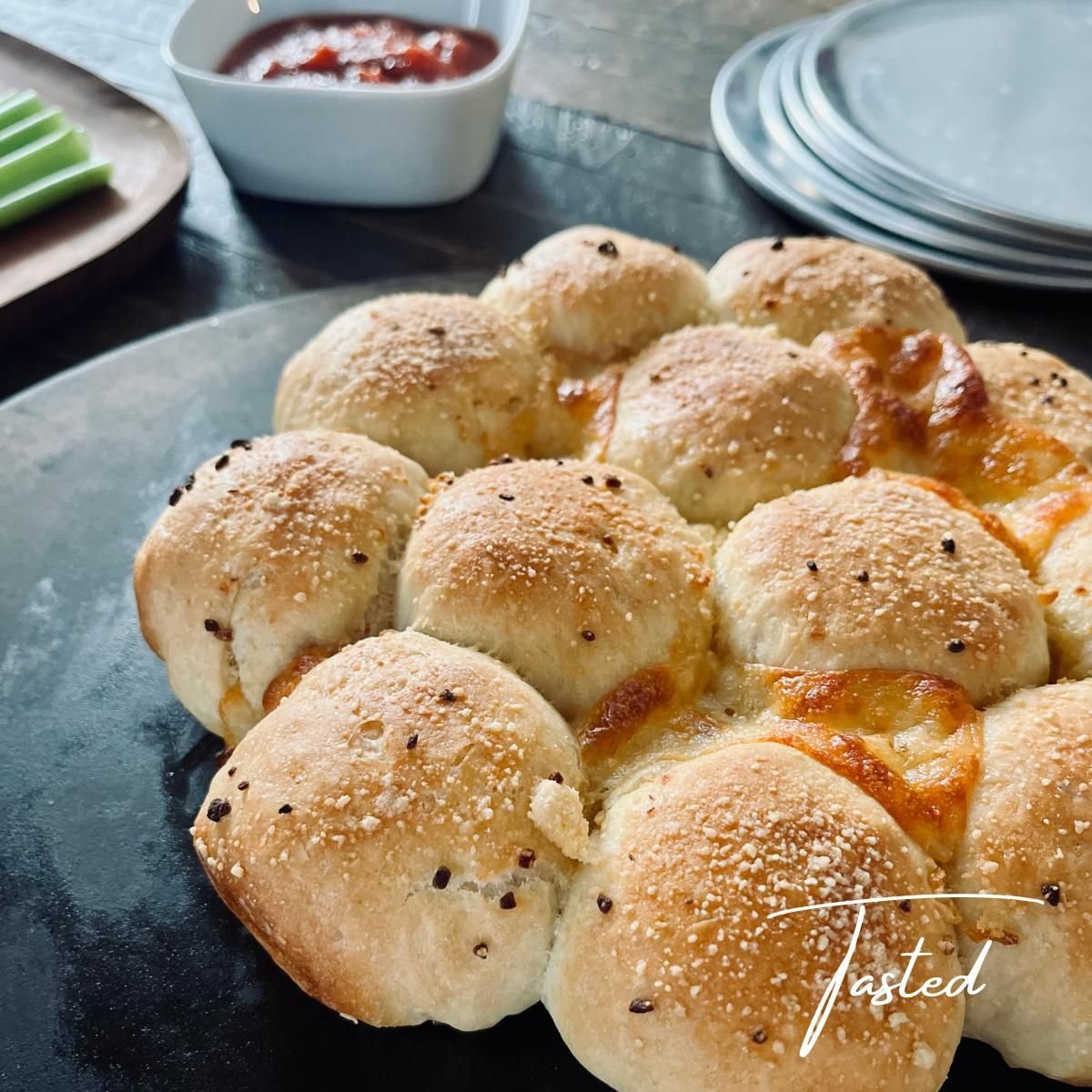 Golden pizza monkey bread with melted cheese between the rolls, with marinara sauce for dipping