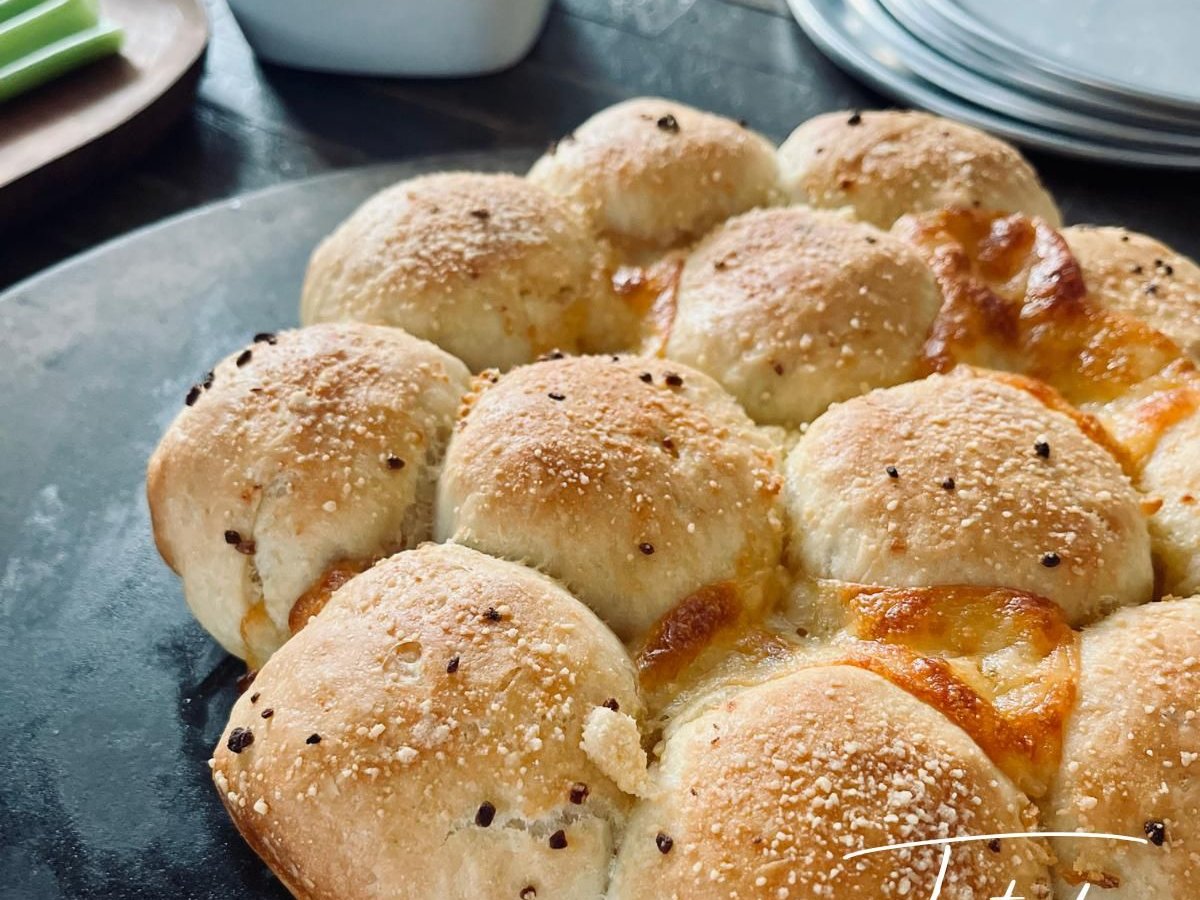 Golden pizza monkey bread with melted cheese between the rolls, with marinara sauce for dipping