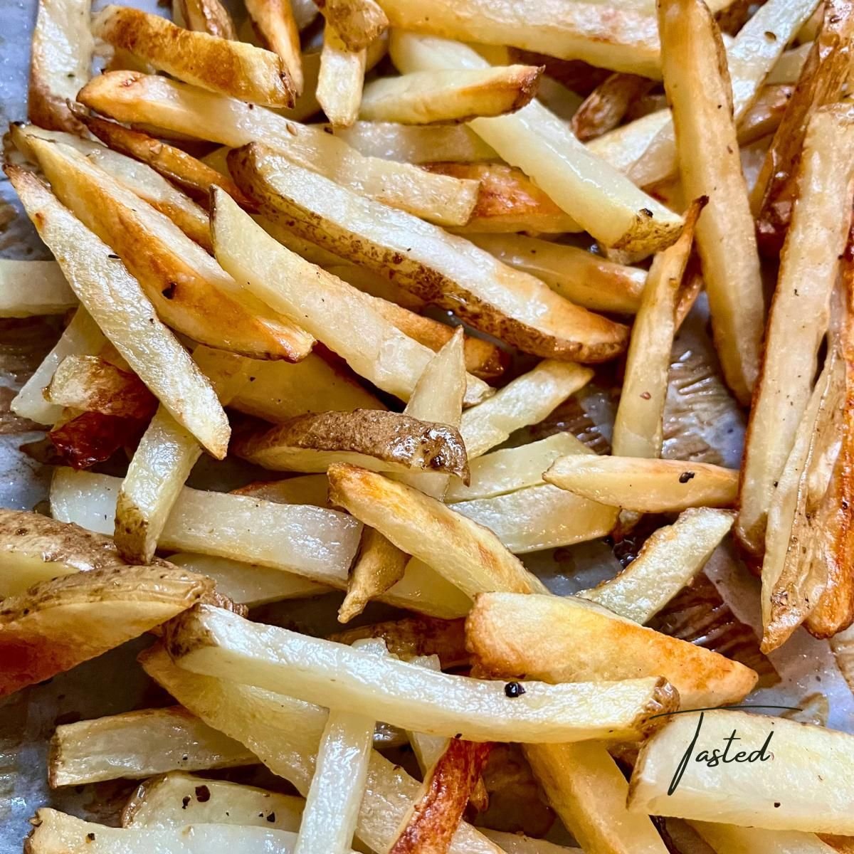 Oven-baked french fries with golden, crispy edges on a baking sheet