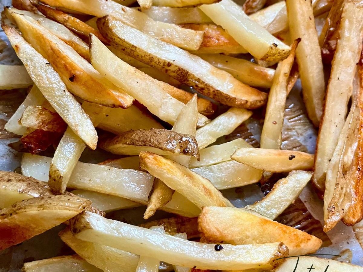 Oven-baked french fries with golden, crispy edges on a baking sheet